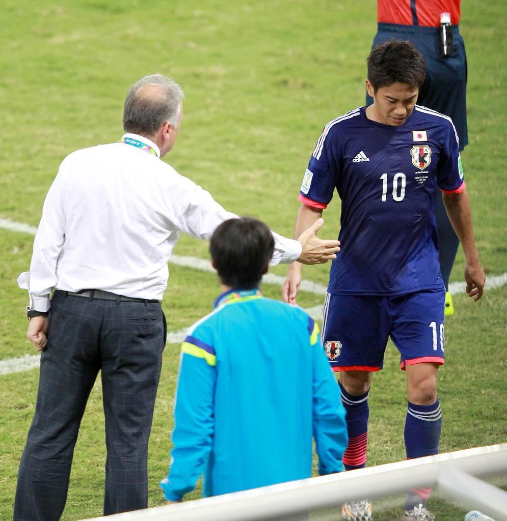 後半、途中交代でザッケローニ監督と握手する香川（右）＝ブラジル・クイアバのパンタナル・アリーナ（ＡｒｅｎａＰａｎｔａｎａｌ）（撮影・山田喜貴）