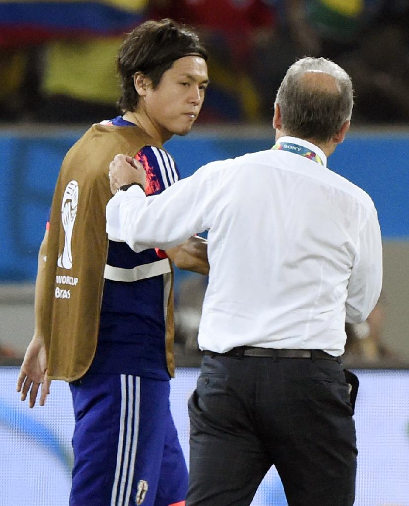 試合後、ザッケローニ監督（右）にねぎらわれる遠藤＝クイアバ（共同）