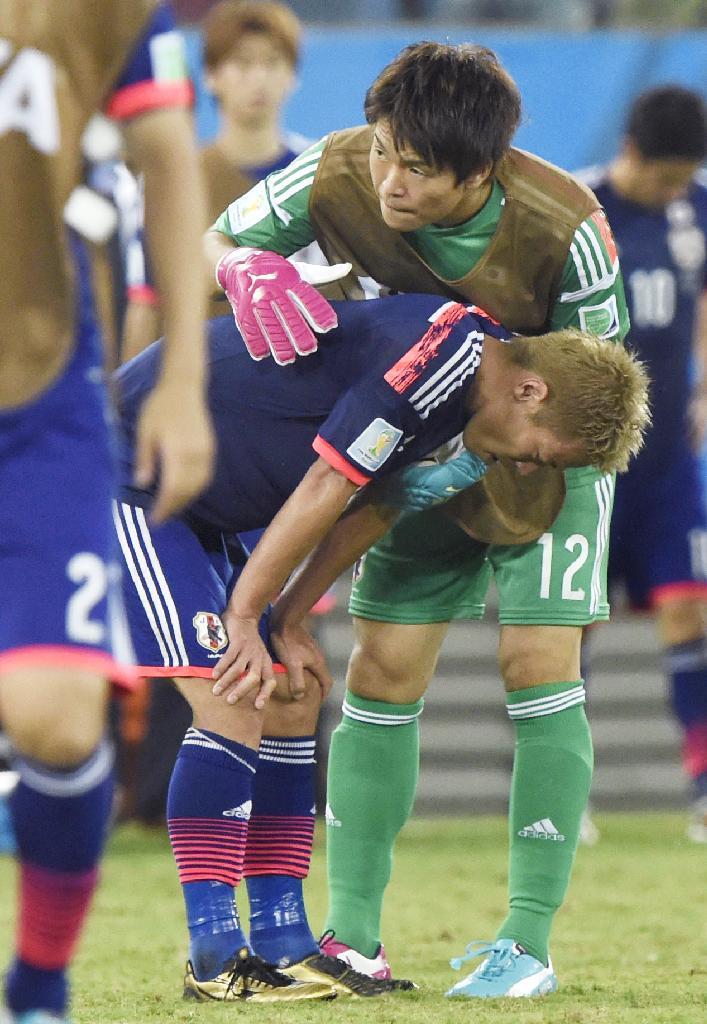 １次リーグ敗退が決まり、肩を落とす本田（手前）に声を掛けるＧＫ西川＝クイアバ（共同）