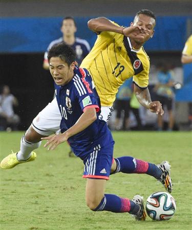 日本－コロンビア後半、グアリン（奥）と競り合い倒される香川＝クイアバ（共同）