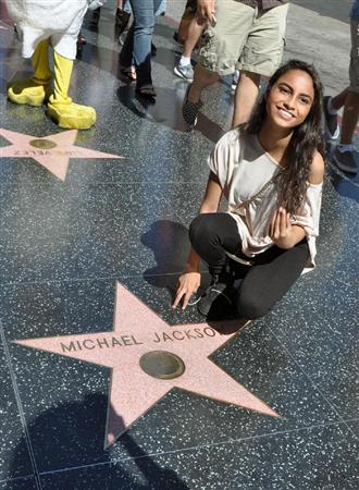 １６日、米ロサンゼルス・ハリウッドで、マイケル・ジャクソンさんの殿堂入りを記念した星形プレートとともに写真を撮るファン（共同）