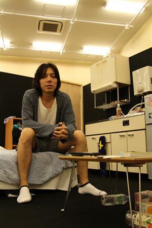 稽古場に組まれた裕一のアパートのセットにて、「さっき起きたところなんです」と話した演出家の三浦大輔さん＝２０１４年６月２４日（津川綾子撮影）
