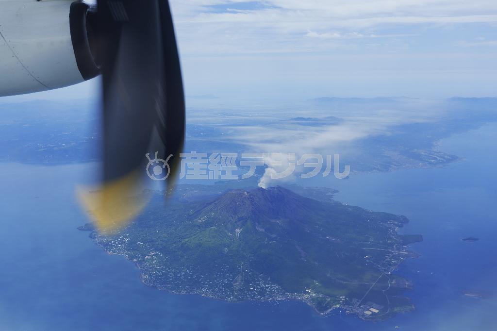 双発プロペラ機ＤＨＣ８－Ｑ４００が鹿児島空港を離陸。ジェット旅客機よりも低い高度を飛ぶため、白煙を上げる桜島が間近に迫る＝２０１４年５月２７日（倉谷清文さん撮影）