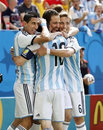 アルゼンチン－ベルギー前半、先制ゴールを決め、メッシ（１０）、ディマリア（左）らと抱き合って喜ぶアルゼンチンのイグアイン（中央）＝ブラジリア（共同）