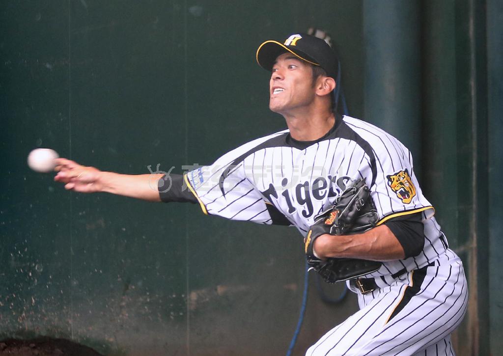 縦縞のユニホームに袖を通し、ブルペンで投げる建山義紀さん＝２０１４年６月２７日、兵庫県西宮市・鳴尾浜球場（安部光翁撮影）