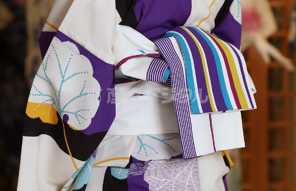 「撫松庵」の浴衣（３万３０００円）と半巾帯（２万３０００円）は、色・柄ミックスで遊び心がたっぷり。帯の後ろ姿のストライプは流行のスポーツテイスト（写真）。白い日傘や、透明感のあるヘアアクセサリー（コンプレックスビズ＿右９０００円、左２万円）で涼しげに＝２０１４年６月３０日、東京都中央区・松屋銀座（小野淳一撮影）