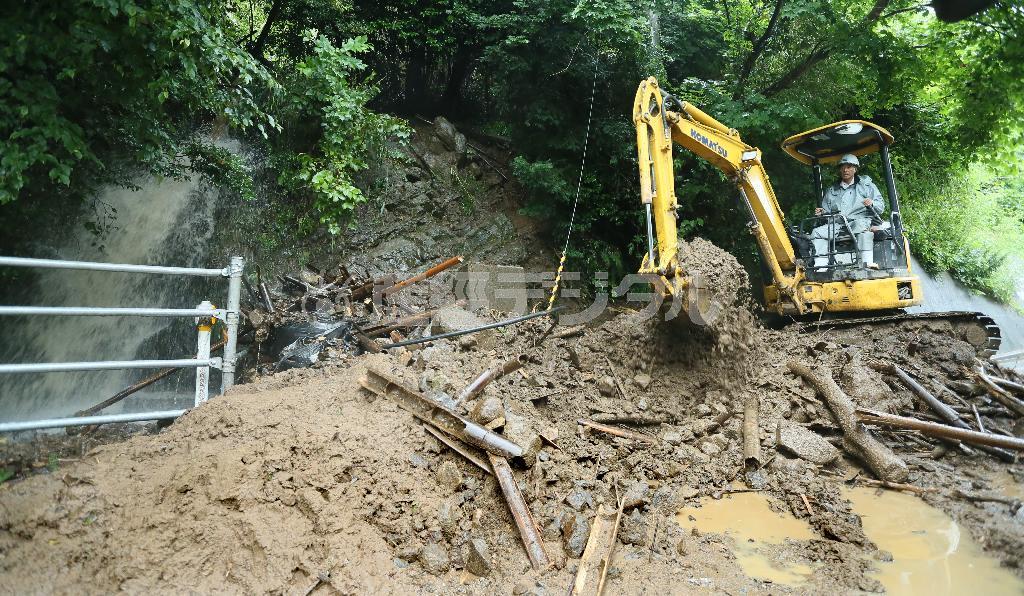 新潟・佐渡島でも大雨で土砂崩れが発生し、県道が一時通行止めとなった＝２０１４年７月９日午後、新潟県佐渡市（大山文兄撮影）