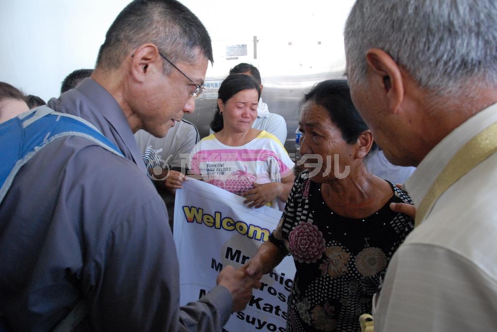 フィリピンで初対面を果たし固く握手を交わす宮里強さん（左）と、叔母に当たるミヤサト・コンチータさん＝２０１４年５月１６日（日本財団提供）