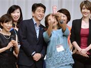 「国際女性ビジネス会議」に出席した女性たちと記念写真に納まる安倍首相＝１３日、東京都内のホテル