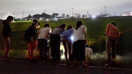 稽古の後に、田んぼでリサーチをする参加メンバーたちの後ろ姿。そこで何を見ているのでしょうか（鈴木拓さん撮影、提供写真）