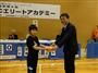 協和発酵キリンの花井陳雄社長（右）から、特製ロゴ入りのタオルを手渡される小学５年の原田春輝君＝６月９日、東京都板橋区
