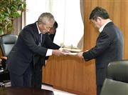 茂木経産相（右）に報告書を手渡すベネッセホールディングスの原田泳幸会長兼社長＝１７日午前、経産省