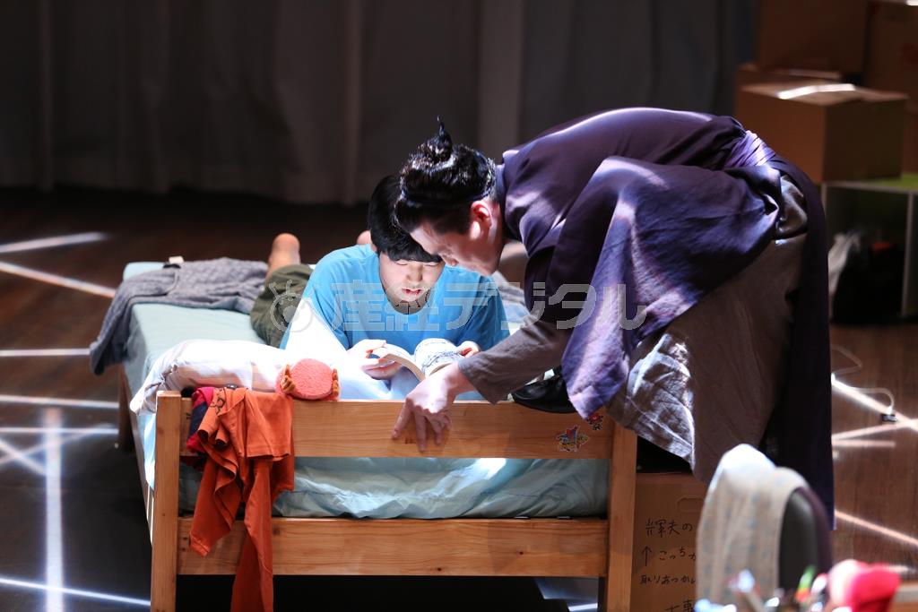 「暗いところからやってくる」の２０１２年上演時の１シーン。マンガを読む輝夫に「なにか」の気配が近づく＝２０１２年７月２４日（田中亜紀さん撮影、提供写真）