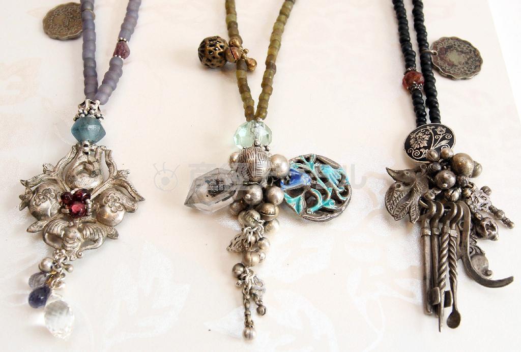 日本人夫妻「Ｍｉｎａｋｕｓｉ（ミナクシ）」の作品。中央は、ペンダントトップがヒマラヤの双頭水晶と、ヤオ族のアンティーク銀製七宝装飾品を組み合わせ、リサイクルガラスを使ったインドネシアのハンドメードビーズを連ねた（８万１０００円）＝２０１４年６月１８日、東京都渋谷区（野村成次撮影）。※価格はすべて税別です。