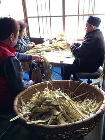 一つ一つ手作業で白楮についた傷や汚れを取り除く作業。福西和紙本舗では、家族総出で行なっている＝２０１４年１月２８日（提供写真）