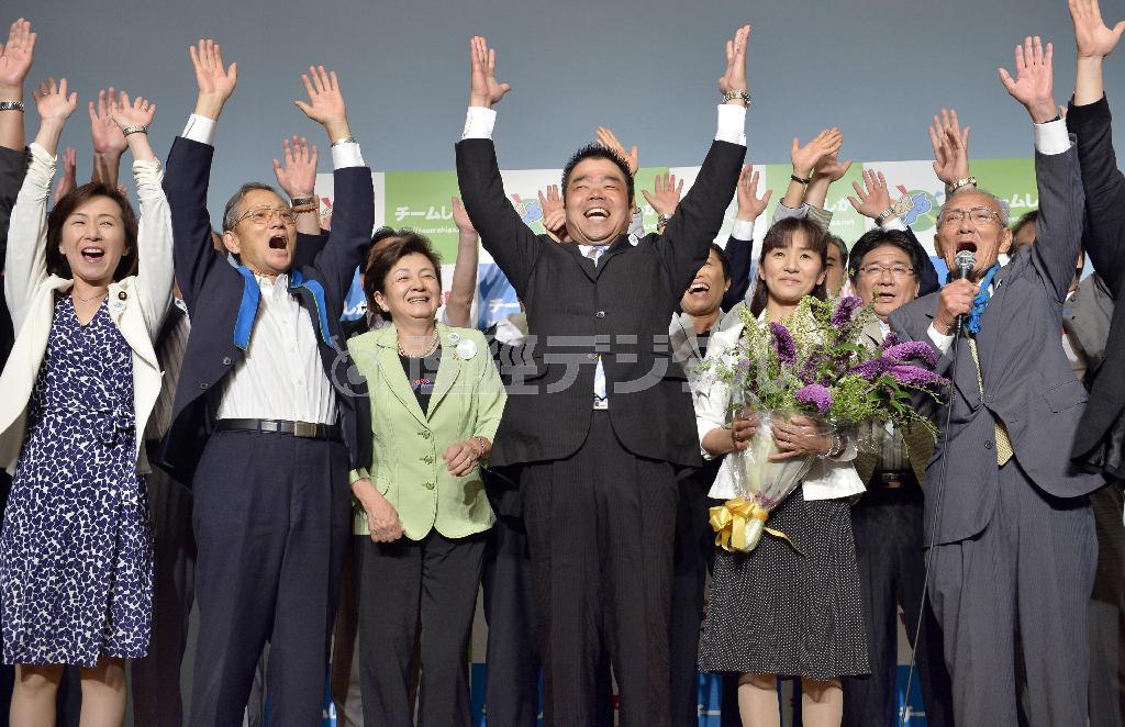 滋賀県知事選で当選を決め、支持者らと万歳する民主党元衆院議員の三日月大造（みかづき・たいぞう）氏（中央）。与党候補の敗北は安倍政権の退潮を意味するのか＝２０１４年７月１３日夜、滋賀県大津市（共同）