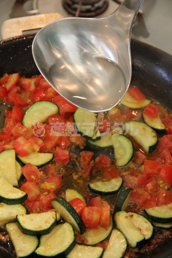 うなぎとズッキーのパスタ（作り方１）＿＿フライパンにオリーブ油、にんにくを入れ、弱火で色づくまで炒め、ズッキーニを加える。ズッキーニがしんなりしてきたらフルーツトマトを加える。煮崩れしてきたら、うなぎ、お玉１～２杯のスパゲティのゆで汁を加え、少し煮詰めて、味を調える。