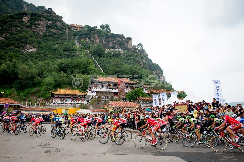 老爺山の前を疾風のごとく走り抜けてゆく選手たち＝２０１４年７月７日、中国・青海省（田中苑子さん撮影）