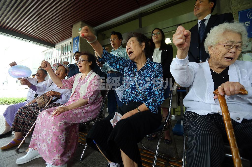 ソウル東部地方裁判所で７月９日開かれた「帝国の慰安婦」訴訟の第１回口頭弁論後、著者の謝罪などを求めて拳を振り上げる元慰安婦ら＝２０１４年、韓国・首都ソウル（聯合）