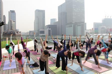 都会のど真ん中、ビルの谷間に囲まれた屋上で行うヨガはひと味違う＝２０１４年５月１４日、東京都千代田区・ＪＲ東京駅前丸の内南口の「ＫＩＴＴＥ」ビル（田中幸美撮影）