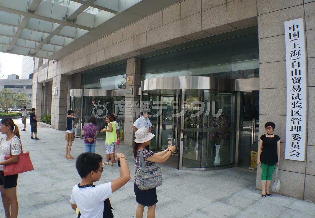 上海市郊外に２０１３年９月に設置された「中国（上海）自由貿易試験区」（ＦＴＺ）の管理委員会が入居しているビルで記念撮影する親子連れ。中国初の試みであるＦＴＺが夏休みの人気スポットになっていた＝２０１４年７月２９日、中国（河崎真澄撮影）