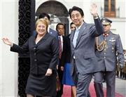 チリのミチェル・バチェレ大統領（左）と会談に向かう安倍晋三（しんぞう）首相＝２０１４年７月３１日、チリ・首都サンティアゴの大統領府（共同）