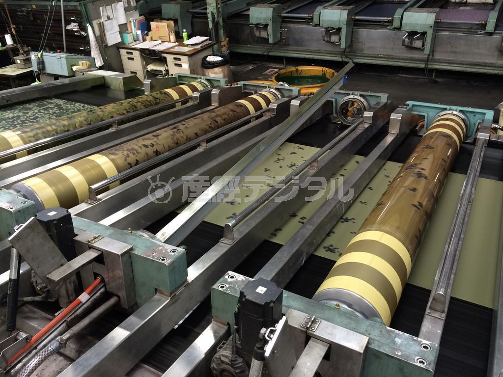 緑色に地染めされた生地に迷彩柄がプリントされる＝大阪府島本町の大阪染工（同社提供）