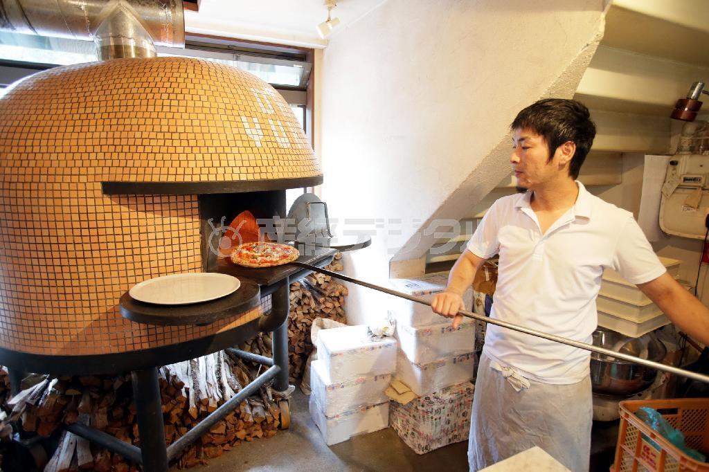 薪窯でピッツァを焼くオーナーシェフの鎌田友毅さん＝２０１４年７月２５日、京都市左京区（門井聡撮影）