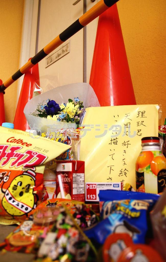 ５月末に斎藤理玖ちゃん＝死亡当時（５）＝の白骨遺体が発見されたアパートの部屋の前に備えられた花やお菓子。２００８年春には小学校にも入学しなかったのに発見できなかった児童相談所などの対応が問題となった＝２０１４年６月２３日、神奈川県厚木市（岩崎雅子撮影）