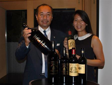 ２０１２年ビンテージを手にするアジア担当ＰＲマネージャーのボング・グルラ・トラムさん（左）と、ソムリエの田崎真也さん＝２０１４年７月３０日（青木冨美子さん撮影）