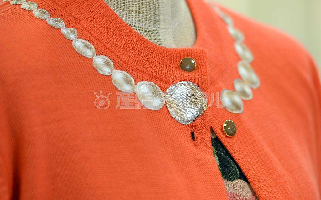 着れば心が躍りそうな、だまし絵（トロンプルイユ）のデザイン。紺の半袖ニットと同じデザインのカーディガンも首もとにパールネックレスっぽく布地をオン＝２０１４年８月４日、東京都中央区（川口良介撮影）