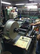 金銀などを蒸着して加工したフィルムを糸状に裁断する「スリット」作業＝２０１４年６月１７日（提供写真）