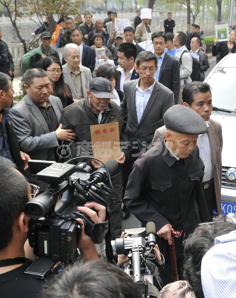 日中戦争時の強制連行をめぐり、河北省高級人民法院に損害賠償などを求めて提訴に向かう元労働者ら。被害を受けた中国人を探し出しては提訴を後押ししてきた反日活動家らは今、皇居内で保管されている唐代の石碑を新たな標的にし始めた＝２０１４年４月２日、中国・河北省石家荘市（共同）