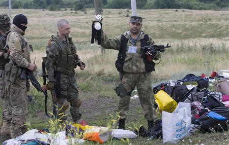 ウクライナ東部のマレーシア航空機墜落現場で、残骸から見つかった人形を持つ親露派兵士。掠奪が行われたケースもあったとすれば、それは受け継がれたロシア軍の「血」である＝７月１８日（ＡＰ）