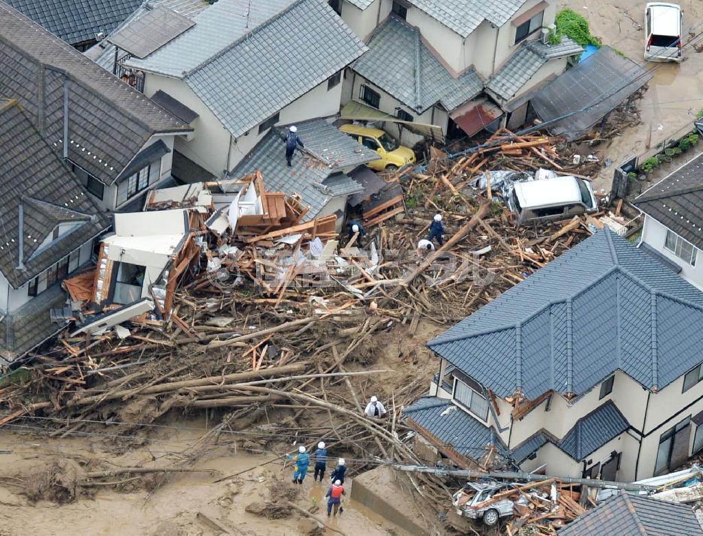 土砂崩れで大量の木が流れ込んだ広島市安佐南区の住宅街＝２０日午前９時２分、共同通信社ヘリから