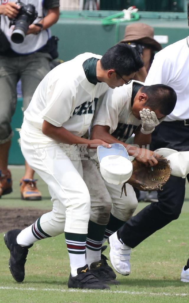 全身から力が抜け、半田真一監督（左）に抱えられるように山根翔希（右）は球場を後にした＝２０１４年８月１３日、兵庫県西宮市・甲子園球場（松永渉平撮影）