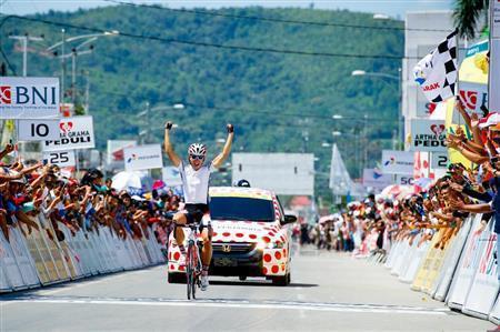 第６ステージで２回目のステージ優勝を挙げた内間康平がフィニッシュラインで大きく両手を掲げた＝２０１４年６月、インドネシア・西スマトラ州（田中苑子さん撮影）