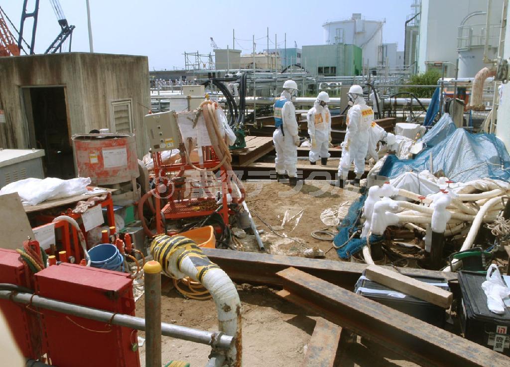 東京電力福島第１原発２号機の海側で、トレンチの凍結に向け準備を進める作業員。地中にトレンチが通っている＝２０１４年７月２９日、福島県（東京電力提供）