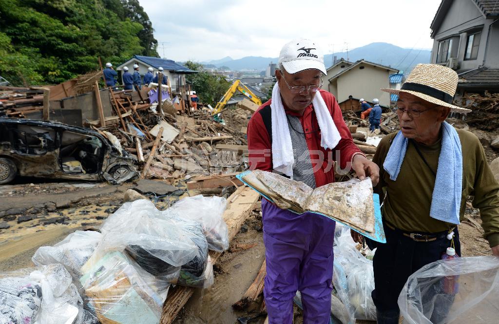行方不明になっている親戚の思い出の品を探す人たち＝２０１４年８月２６日午後、広島県広島市安佐南区緑井（鴨川一也撮影）