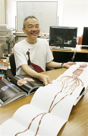 本書の特別付録である特大サイズの魚拓ならぬ「イカ」拓を手にする、編集者の澤井聖一さん＝２０１４年８月１８日（塩塚夢撮影）