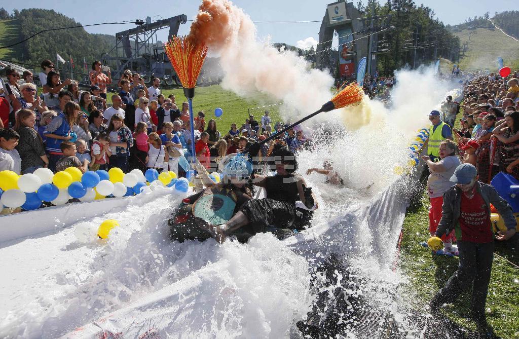 スキー場につくられたプールで遊ぶ参加者＝２０１４年８月２４日、ロシア・クラスノヤルスク郊外（ロイター）