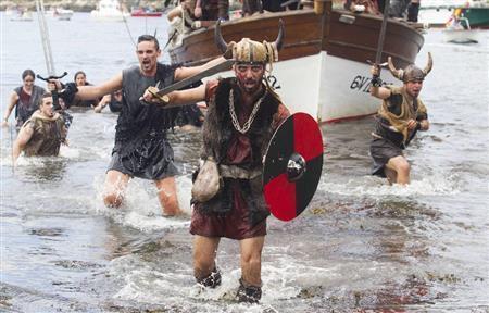 祭りで海賊の姿になって陸に上がる男たち＝２０１４年８月３日、スペイン・ガリシア州カトイラ（ロイター）