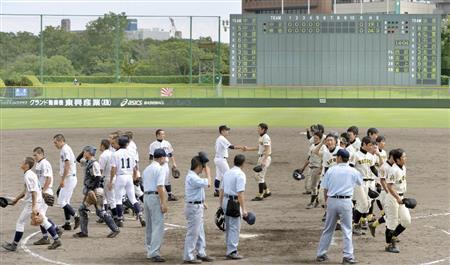 第５９回全国高校軟式野球選手権大会の準決勝で、延長４５回まで戦っても勝負がつかず引き揚げる中京（左）と崇徳の選手＝２０１４年８月３０日午後、兵庫県明石市の明石トーカロ球場（共同）