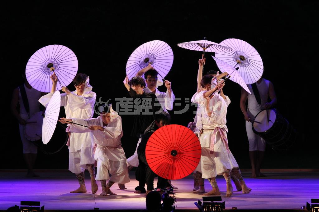 鼓童との初共演で演目の一部をアレンジした「花ト囮」を披露するＤＡＺＺＬＥ。和傘が万華鏡のようにめまぐるしく変化し、限りない幻想世界が広がる＝２０１４年８月２４日、新潟県佐渡市小木町の城山公園（田中幸美撮影）