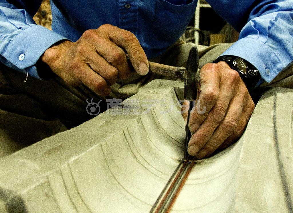 「鋳ぐるみ」という技法で、地金にステンレス線や銅線を埋め込み、火や水、宇宙などを表現する＝富山県高岡市（井浦新さん撮影）