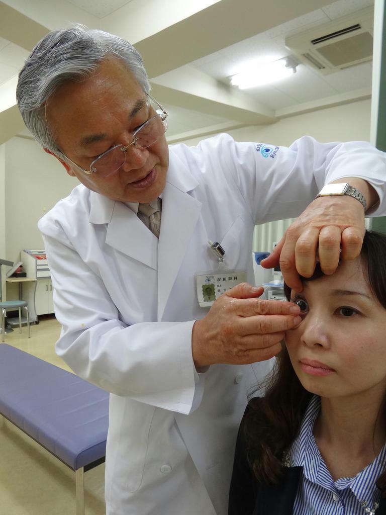 遠近両用のコンタクトレンズを試す女性。梶田雅義医師は「頭痛や肩凝りなど仕事が原因と思う不調も目が原因の場合が多い」と話す＝東京都港区（日野稚子撮影）