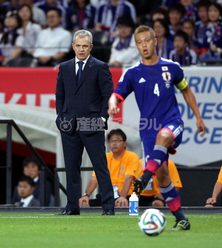 日本代表のキャプテンマークを巻く本田圭佑（けいすけ、手前）のプレーを鋭い視線で見つめるハビエル・アギーレ監督＝２０１４年９月５日、北海道札幌市豊平区・札幌ドーム（高橋茂夫撮影）