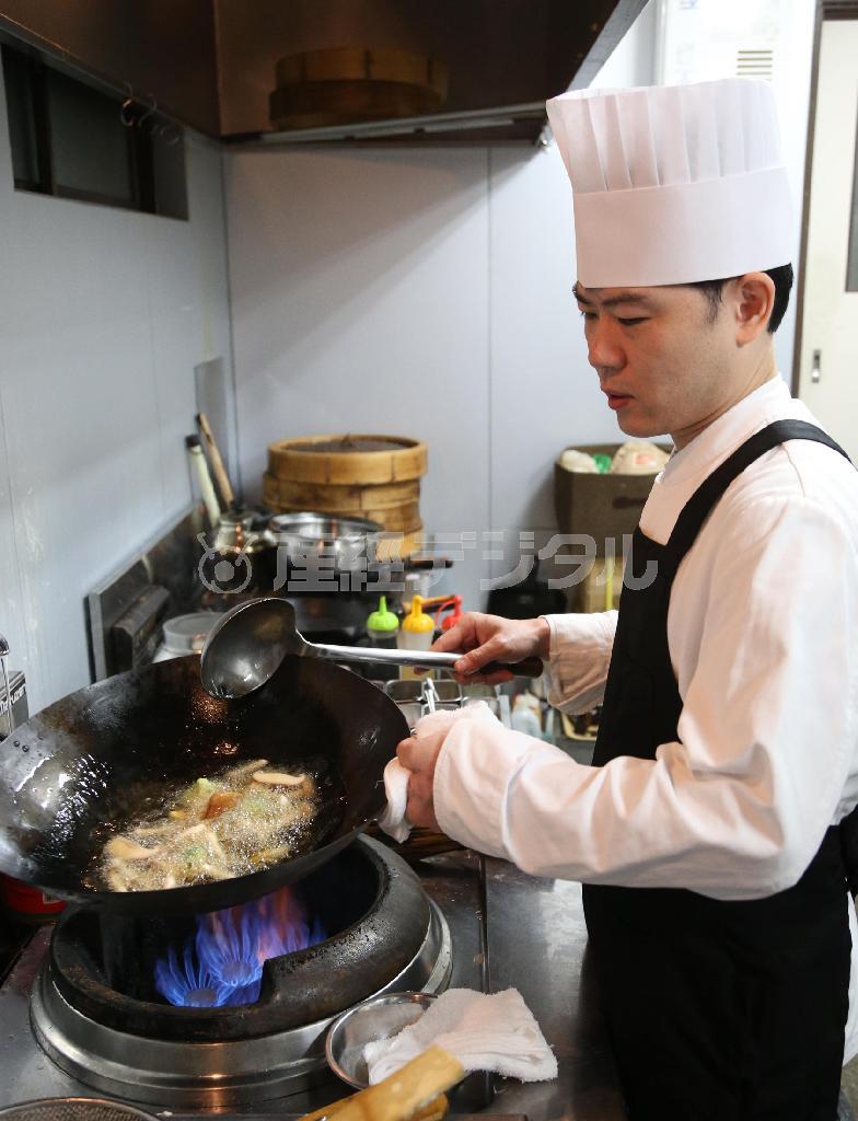 巧みに火を操り鍋を振る店主の亀山貴さん＝２０１４年９月１日、京都市北区（恵守乾撮影）