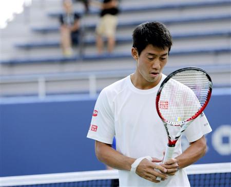 決勝に向けた最終調整の合間、ラケットを見つめる錦織圭＝７日、ニューヨーク（共同）