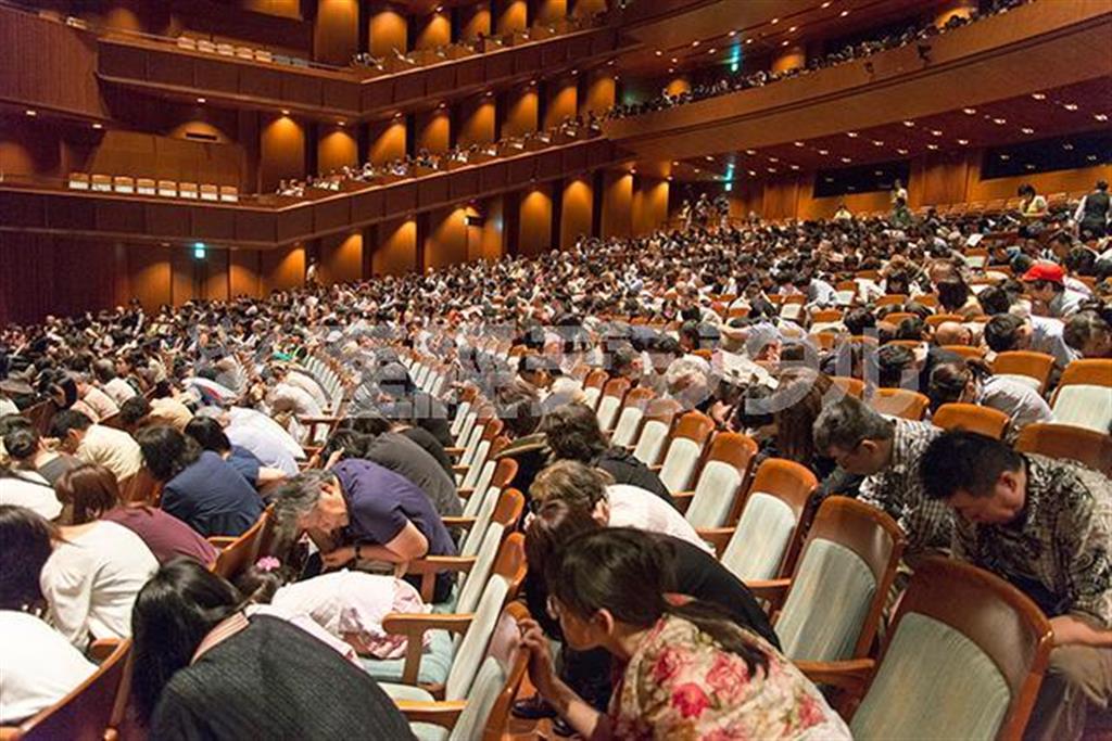 訓練中、客席で頭を低くして劇場スタッフの指示を待つ観客（寺司正彦さん撮影、提供写真）